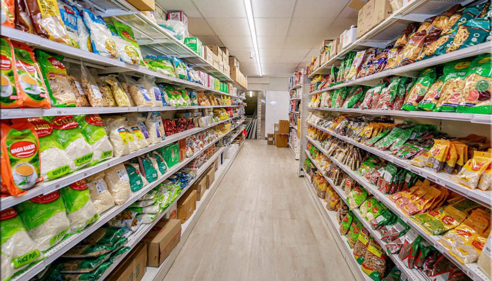 Grocery aisle stocked with Indian snacks, rice and pantry staples